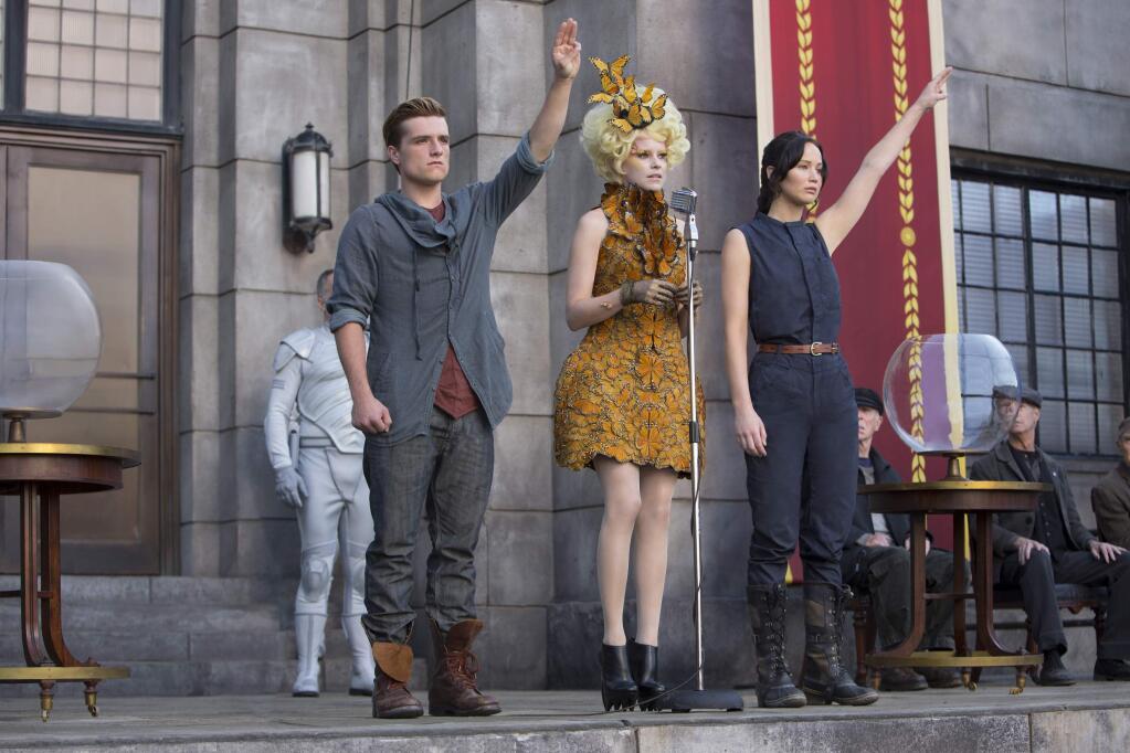 FILE - This image released by Lionsgate shows, from left, Josh Hutcherson as Peeta Mellark, Elizabeth Banks as Effie Trinket and Jennifer Lawrence as Katniss Everdeen in a scene from the film, 'The Hunger Games: Catching Fire.' A fictional gesture from a Hollywood movie is being used as a real symbol of resistance in Thailand. Protesters against a military coup are flashing the three-finger salute from ìThe Hunger Gamesî as a silent act of rebellion, and theyíre being threatened with arrest if they ignore warnings to stop. (AP Photo/Lionsgate, Murray Close)