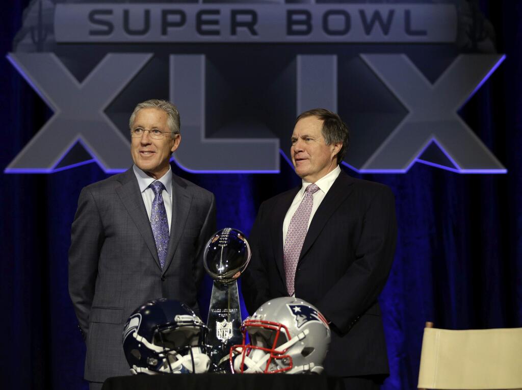 Seahawks coach Pete Carroll, left, and Patriots coach Bill Belichick pose with the Vince Lombardi Trophy. (David J. Phillip / Associated Press)