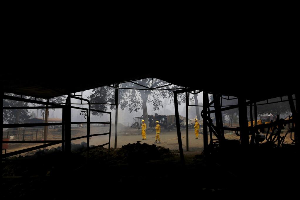 A group of Cal Fire firefighters search through remains from the Valley fire in Middletown, on Monday, September 14, 2015. (BETH SCHLANKER/ The Press Democrat)