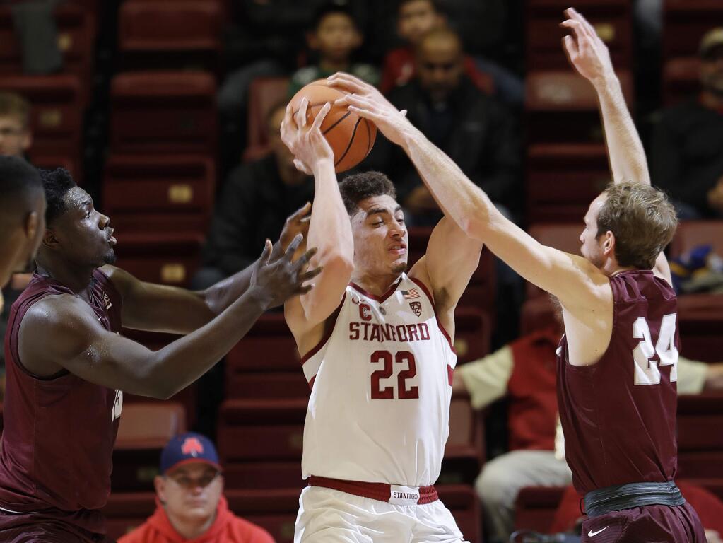 Stanford forward Reid Travis (22) is defended by Montana forward Jamar Akoh, left, and guard Bobby Moorehead during the first half of an NCAA college basketball game Wednesday, Nov. 29, 2017, in Stanford, Calif. (AP Photo/Marcio Jose Sanchez)
