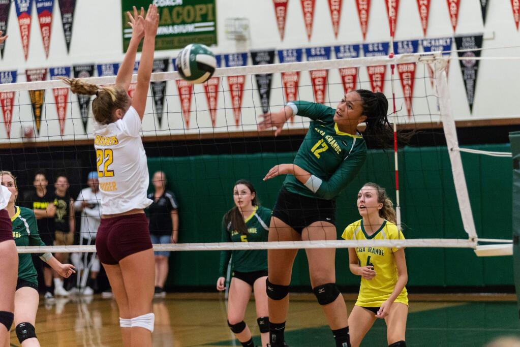 RICH LANGDON/FOR THE ARGUS-COURIERCasa Grande's Lina Fakalata blasts home a kill while teammates Caitlyn Hilliard (5) and April Lu (6) wait to help.