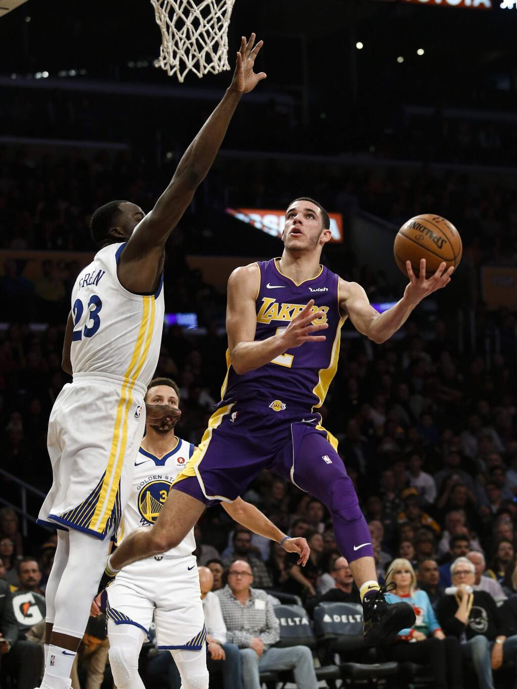 Los Angeles Lakers guard Lonzo Ball, right, looks for a shot as Golden State Warriors forward Draymond Green defends during the first half Wednesday, Nov. 29, 2017, in Los Angeles. (AP Photo/Ringo H.W. Chiu)