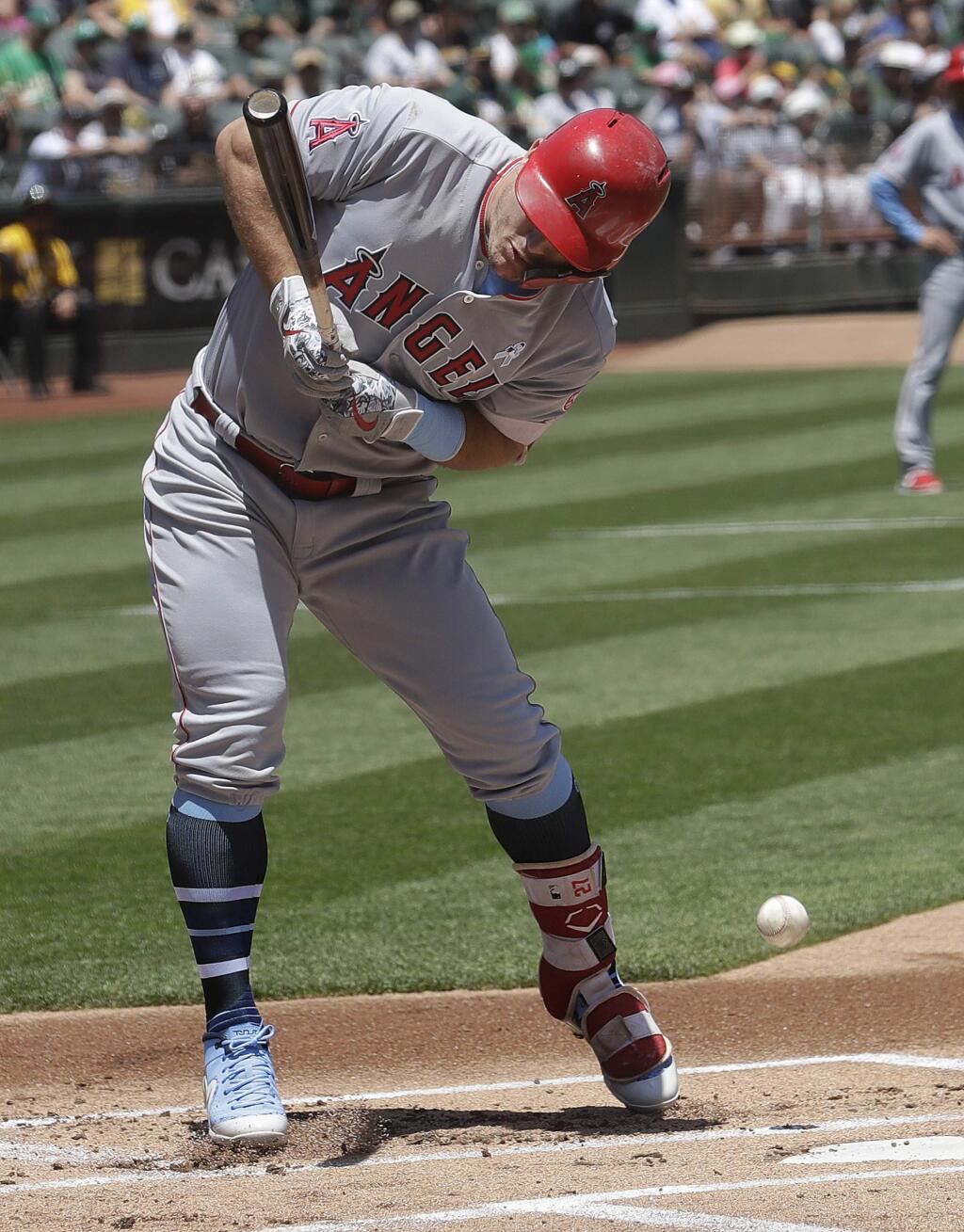 Los Angeles Angels' Mike Trout is hit by a throw from Oakland Athletics pitcher Daniel Mengden during the first inning of a baseball game in Oakland, Calif., Sunday, June 17, 2018. (AP Photo/Jeff Chiu)
