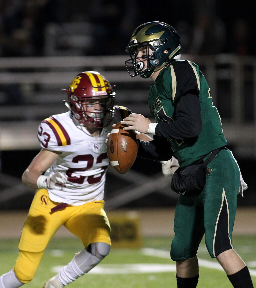 Cardinal Newman's Hunter Graniss, left, charges towards Maria Carrillo quarterback Tyler Monaco in the first half at Maria Carrillo High School in Santa Rosa on Monday, Nov. 4, 2019. (Photo by Darryl Bush / For The Press Democrat)