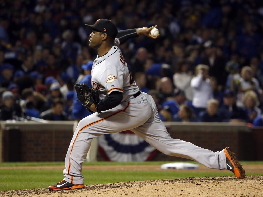 In this Oct. 8, 2016 file photo, San Francisco Giants relief pitcher Santiago Casilla throws in the sixth inning of Game 2 of the National League Division Series against the Chicago Cubs in Chicago. Casilla awaits his paperwork to depart the Dominican Republic and rejoin the Oakland Athletics. (AP Photo/Nam Y. Huh)
