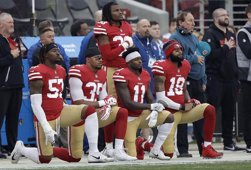 San Francisco 49ers outside linebacker Eli Harold, from bottom left, kneels with safety Eric Reid, wide receiver Marquise Goodwin and wide receiver Louis Murphy during the national anthem before a game against the Jacksonville Jaguars in Santa Clara, Sunday, Dec. 24, 2017. (AP Photo/Marcio Jose Sanchez)