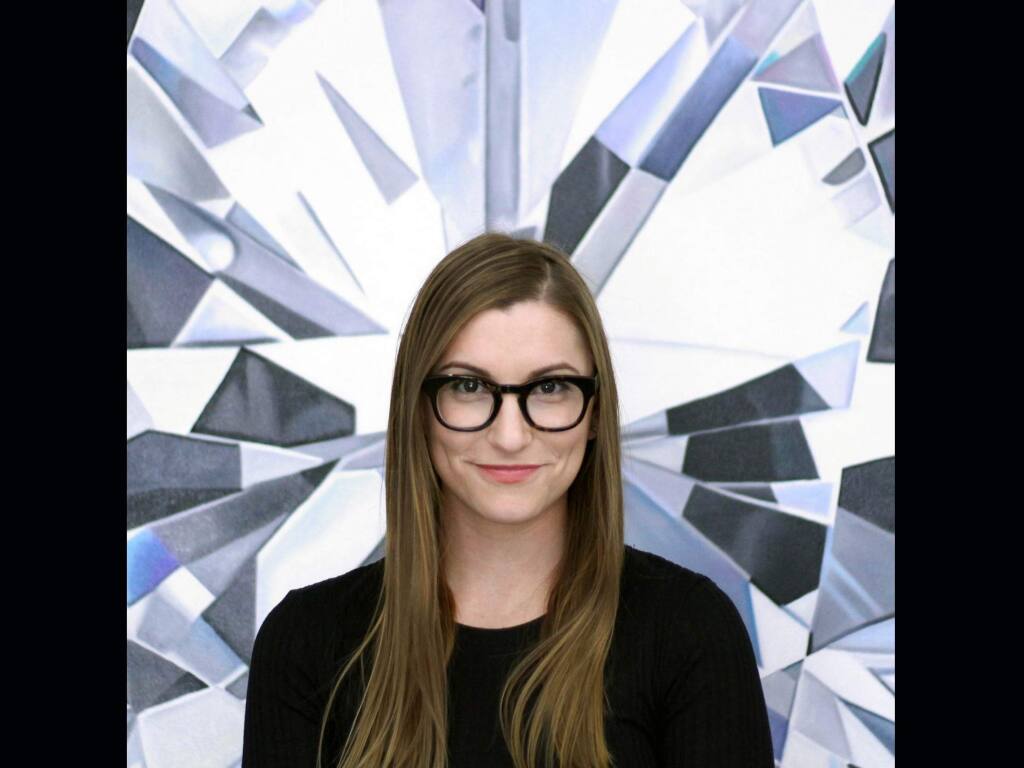 Angie Crabtree stands in front of one of her paintings, a part of a series that shows closeup views of diamonds enlarged 1,000+ times. (Angie Crabtree)