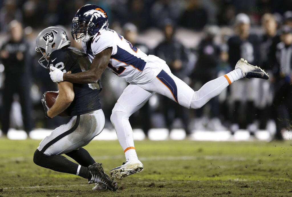 Oakland Raiders wide receiver Jordy Nelson, left, is tackled by Denver Broncos defensive back Tramaine Brock during the first half in Oakland, Monday, Dec. 24, 2018. (AP Photo/D. Ross Cameron)
