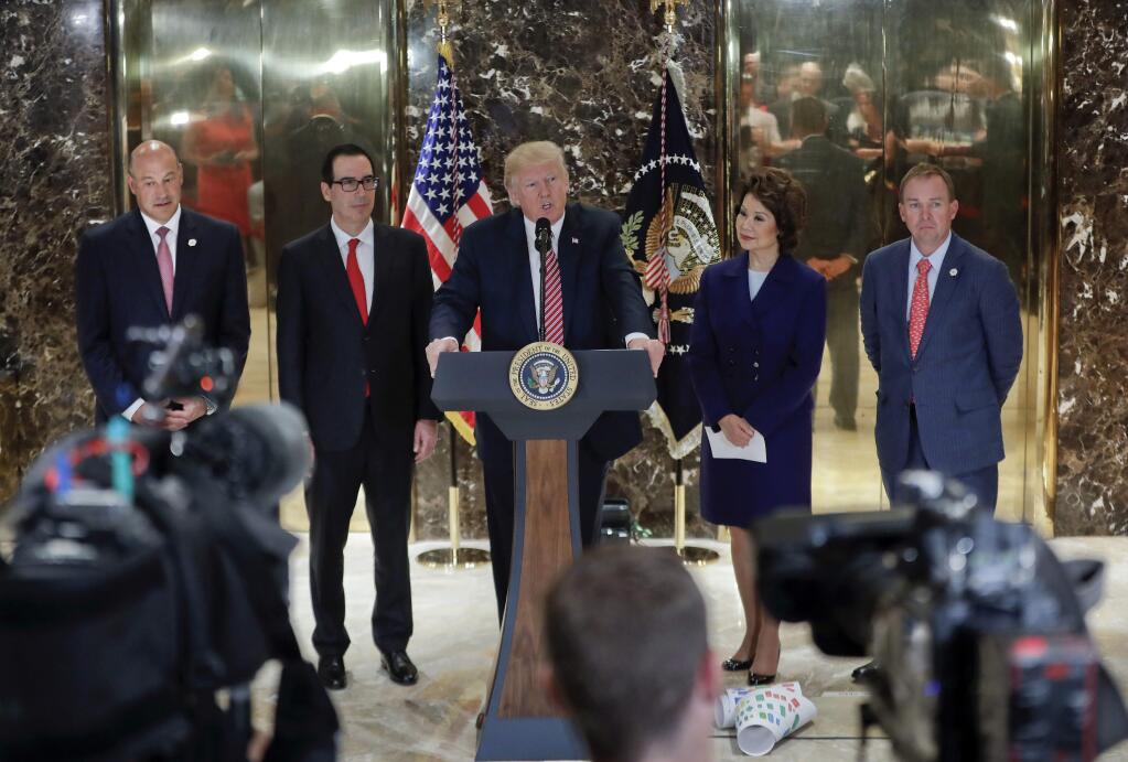 President Donald Trump speaks to the media in the lobby of Trump Tower, Tuesday, Aug. 15, 2017 in New York. With Trump are from left, National Economic Council Director Gary Cohn Treasury Secretary Steven Mnuchin, Transportation Secretary Elaine Chao and OMB Director Mick Mulvaney. (AP Photo/Pablo Martinez Monsivais)