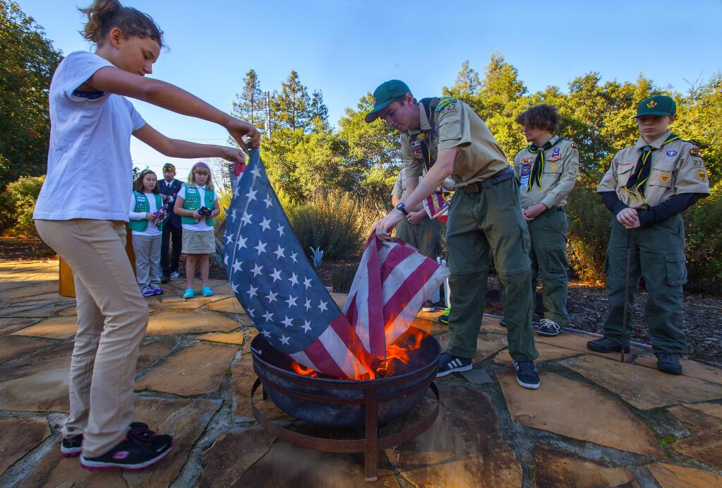 Robbi Pengelly/Index-TribuneRetiring old flagsA small crowd gathered Wednesday, on Veterans Day, in front of the Sonoma Valley Veterans Memorial Hall and witnessed Girl Scout Ella Weber, 10, and Boy Scout Wyatt Lage, 16, ceremonially place one of the first well-used American flags into the fire. When a flag is ready for retirement, the most common method is to respectfully, and with dignity, burn it to ashes. The event was sponsored by the Veterans of Foreign Wars, Bear Flag Post 1943.