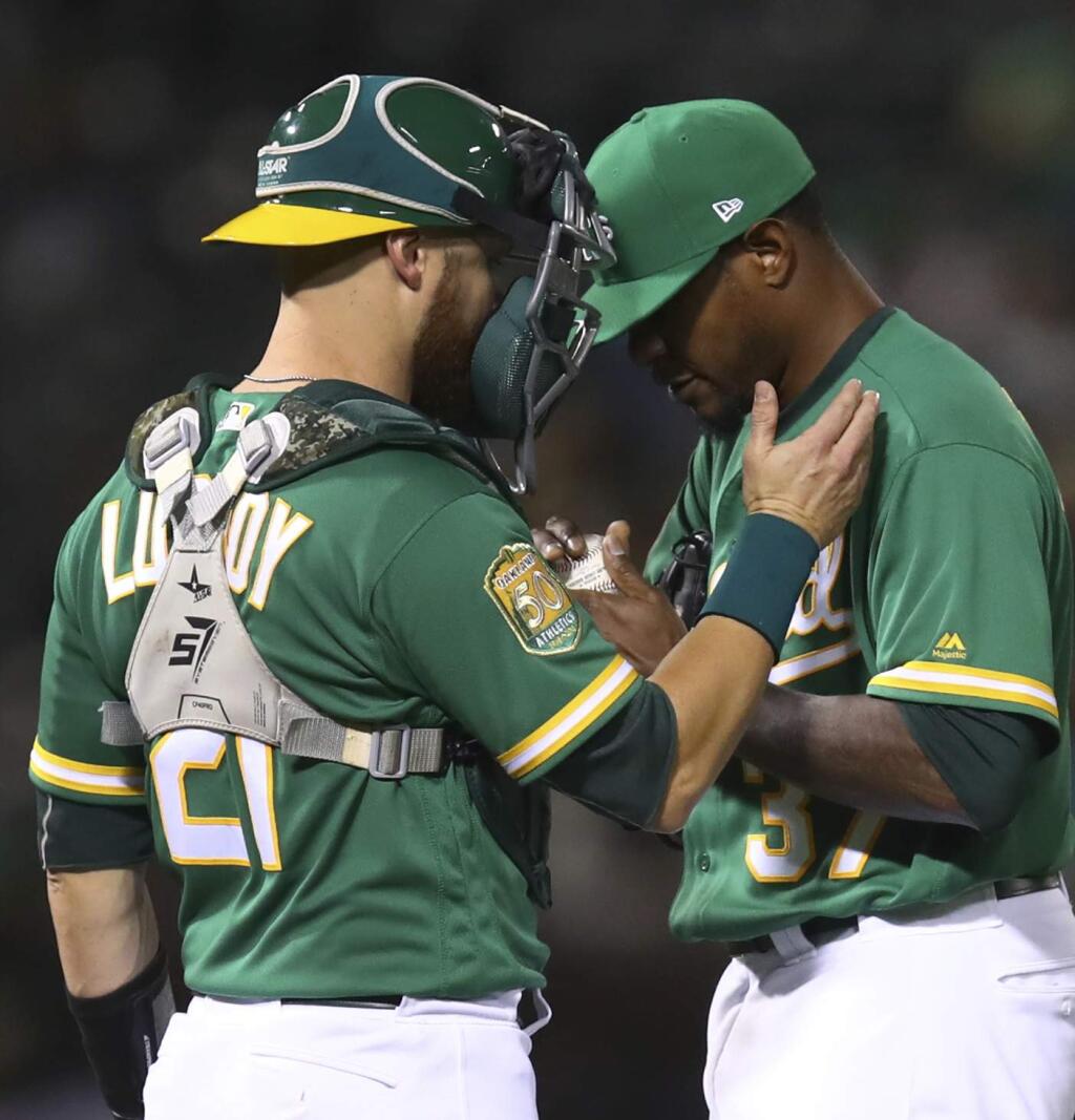 Oakland Athletics' Edwin Jackson, right, meets with Jonathan Lucroy during the fifth inning of the team's baseball game against the Houston Astros on Friday, Aug. 17, 2018, in Oakland, Calif. (AP Photo/Ben Margot)