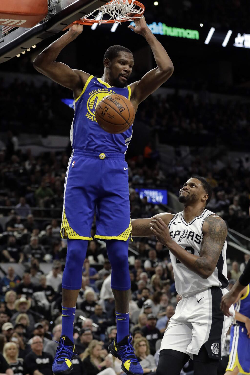 In this April 19, 2018, file photo, Golden State Warriors forward Kevin Durant dunks as the San Antonio Spurs' Rudy Gay watches during the the first half of Game 3 of a first-round playoff series in San Antonio. (AP Photo/Tony Gutierrez, File)