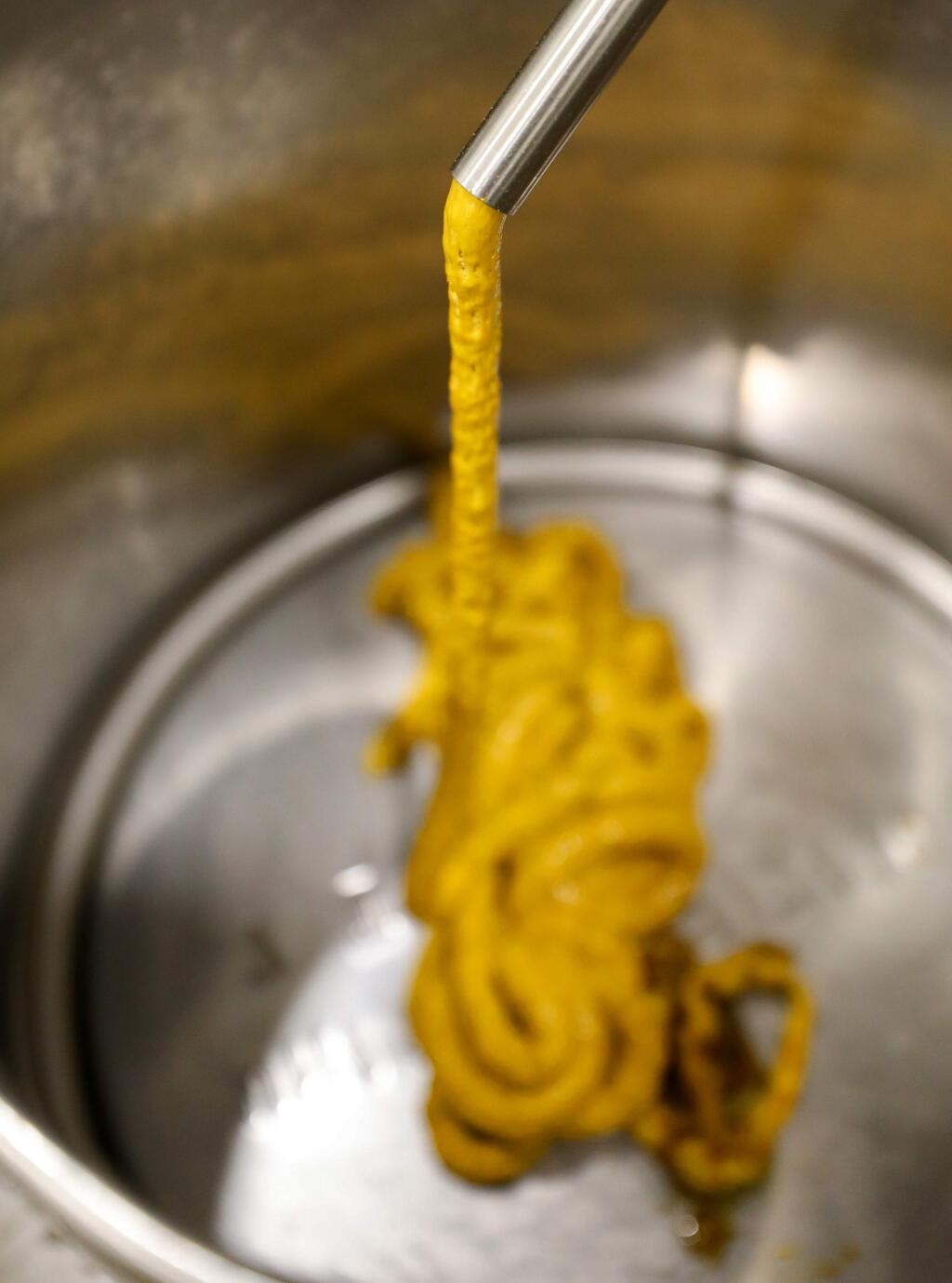Cannabis extract slowly exits an extraction machine, before it is subjected to additional layers of refinement, at the SPARC production facility, in Santa Rosa on Friday, February 14, 2020. (Christopher Chung/ The Press Democrat)