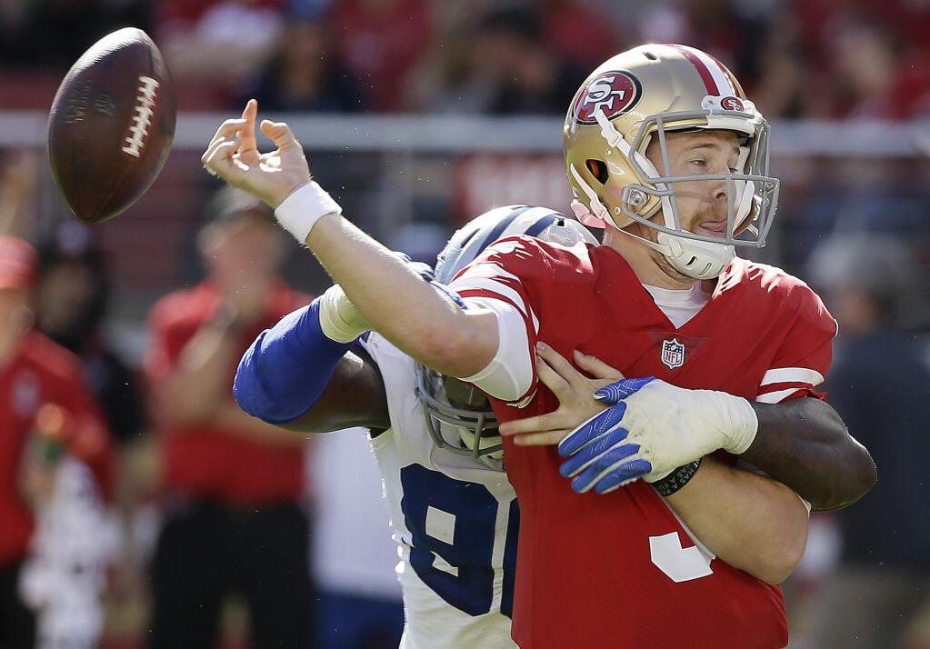 San Francisco 49ers quarterback C.J. Beathard (3) fumbles as he is hit by Dallas Cowboys defensive end Demarcus Lawrence during the first half of an NFL football game in Santa Clara, Calif., Sunday, Oct. 22, 2017. The Cowboys recovered the ball. (AP Photo/Eric Risberg)