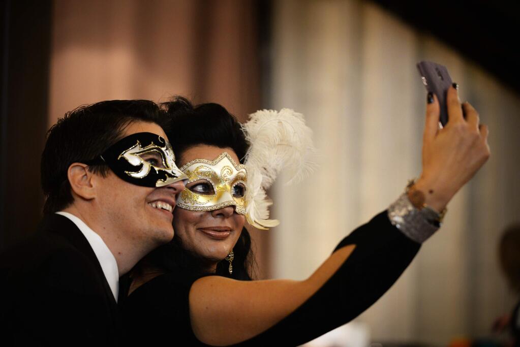 Clay and Krista Thompson take a selfie during the 18th annual 4-A-Child Masquerade Ball, a benefit of the California Parent Institute, held at the DeTurk Round Barn in Santa Rosa on Saturday, Nov. 8, 2014. (ERIK CASTRO/ FOR THE PD)
