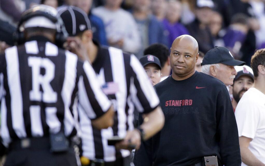 Stanford head coach David Shaw looks on as officials listen while a play is reviewed against Washington in the second half of an NCAA football game Saturday, Sept. 27, 2014, in Seattle. Stanford won 20-13.(AP Photo/Elaine Thompson)