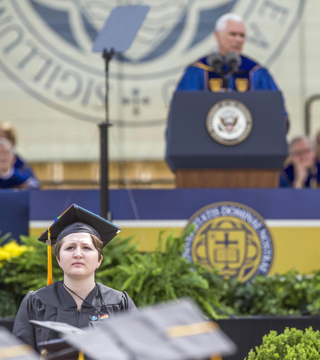 Notre Dame graduate Erin McNamee, a biology major in the school of science, stands with her back to Vice President Mike Pence in protest as he speaks during the 2017 commencement ceremony, Sunday, May 21, 2017, in South Bend, Ind. (Robert Franklin/South Bend Tribune via AP)