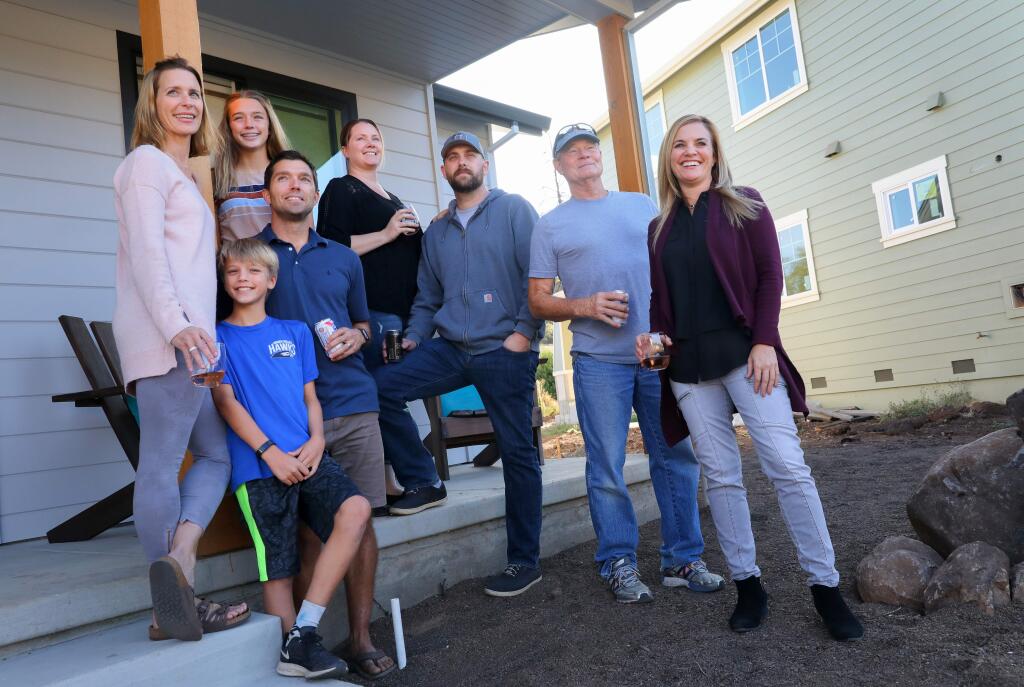 Hidden Valley neighborhood residents Beth Cuniberti, left, Carlo Cuniberti, 10, Lily Cuniberti, 13, Dan Cuniberti, Erica Todhunter, Matt Todhunter, Rich Peters and Tracy Condron were all friends before the Tubbs fire, getting together for block parties on Flintwood Drive in Santa Rosa. The experience of the fire and subsequent rebuilding of their homes have brought them closer together.(Christopher Chung/ The Press Democrat)