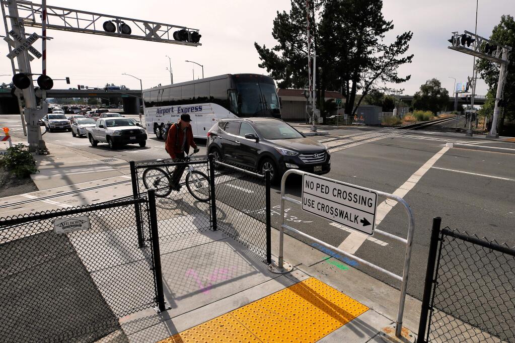 A bicyclist maneuvers back into the bike lane, to get around the newly-installed Z gate for pedestrians where Golf Course Drive intersects with the SMART railway in Rohnert Park, California, on Tuesday, July 9, 2019. Two people were killed by SMART trains at this railway intersection in two separate accidents on consecutive days last month. (Alvin Jornada / The Press Democrat)