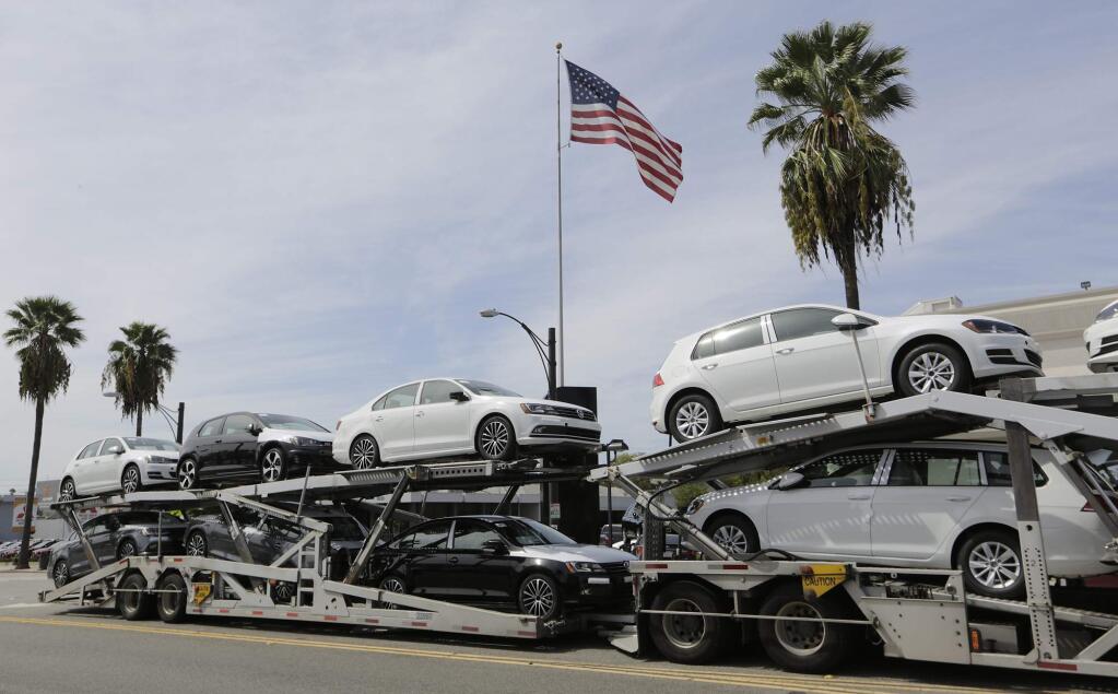 FILE - In this Sept. 21, 2015, file photo, a truck load of gasoline-engine Volkswagens is offloaded outside New Century Volkswagen dealership in Glendale, Calif. A federal judge in San Francisco is set to hear Friday, Dec. 16, 2016, whether Volkswagen, U.S. regulators and attorneys for car owners have reached a deal for the remaining 80,000 cars caught up in the company's emissions cheating scandal. (AP Photo/Damian Dovarganes, File)