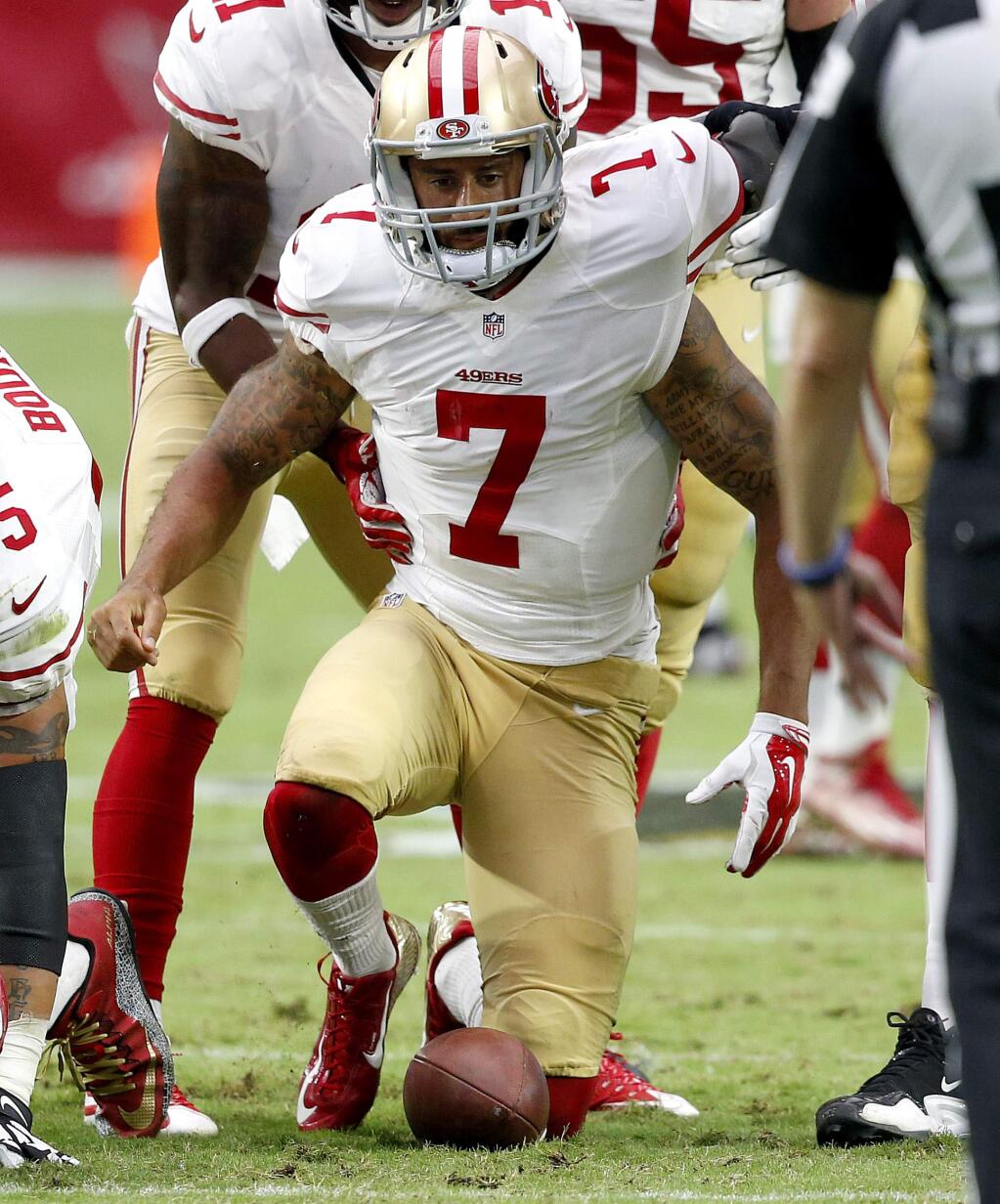 San Francisco 49ers quarterback Colin Kaepernick (7) is helped up after being hit against the Arizona Cardinals during the second half of an NFL football game, Sunday, Sept. 27, 2015, in Glendale, Ariz. (AP Photo/Ross D. Franklin)