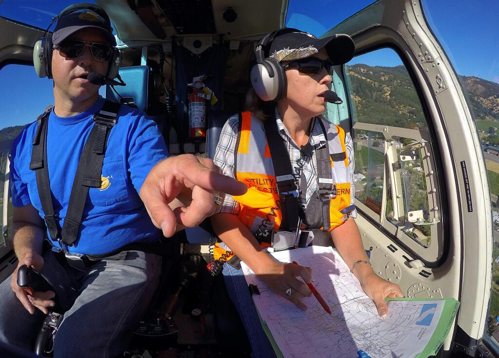A&P Helicopters pilot Joe Ryan, left, and Amy Rowe, a certified arborist with Western Environmental Consultants, Inc., identify dead trees that could pose a wildfire, or other public safety risk, for Pacific Gas and Electric Company in the Ukiah area on Wednesday, June 28, 2017. (Christopher Chung/ The Press Democrat)