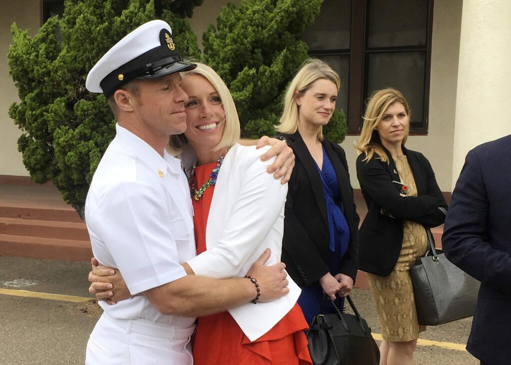FILE - In this Thursday, May 30, 2019, file photo, U.S. Navy Special Operations Chief Edward Gallagher, left, hugs his wife, Andrea Gallagher, after leaving a military courtroom on Naval Base San Diego, in San Diego. Edward Gallagher, who has been charged with allegedly killing an Islamic State prisoner in his care and attempted murder for the shootings of two Iraq civilians in 2017, is scheduled to go on trial Monday, June 17, 2019. (AP Photo/Julie Watson, File)