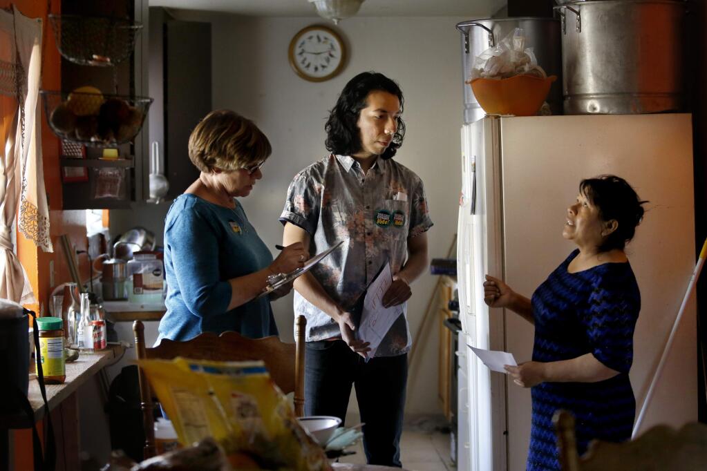 Roseland resident Alejandra Rafael, right, talks with Deborah Mason, left, and Enrique Yarce, volunteers from the North Bay Organizing Project, about the poor conditions of her apartment as they canvass the Roseland area talking with voters in Santa Rosa, on Sunday, April 24, 2016. (BETH SCHLANKER/ The Press Democrat)