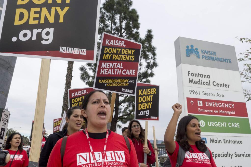 Members of the National Union of Healthcare Workers picket the Kaiser Permanente Fontana Medical Center, Monday, Dec. 10, 2018, in Fontana, Calif. Thousands of Kaiser Permanente mental health professionals throughout California started a weeklong strike Monday to protest what they say is a lack of staffing that affects care. (James Quigg/The Daily Press via AP)