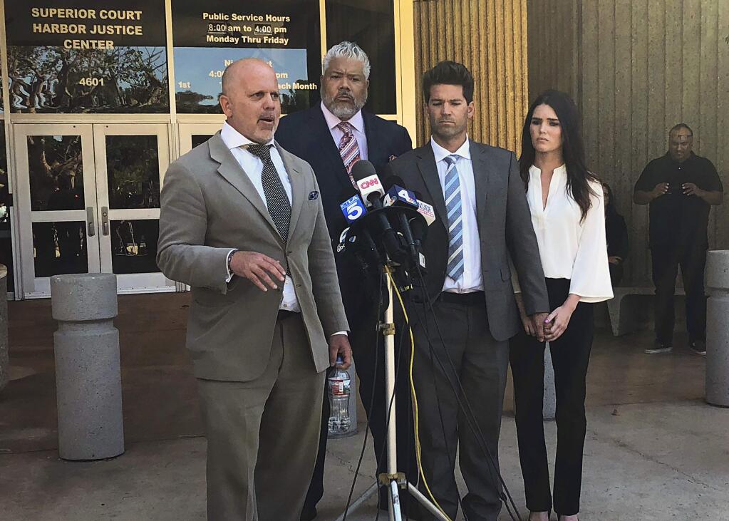 Reality show doctor Grant Robicheaux, second from right, and his girlfriend Cerissa Riley, right, listen as Robicheaux's attorney Philip Cohen, left, speaks outside court in Newport Beach, Calif., following their hearing on new criminal charges involving five additional victims Wednesday, Oct. 17, 2018. The pair were previously charged with drugging and sexually assaulting two women. The Orange County district attorney's office said the additional charges include kidnapping and rape by use of drugs. Robicheaux, 38, and Riley, 31, pleaded not guilty to all counts. A judge ordered their bail to be raised to $1 million each, up from $100,000 each. Man at rear is unidentified. (AP Photo/Amy Taxin)