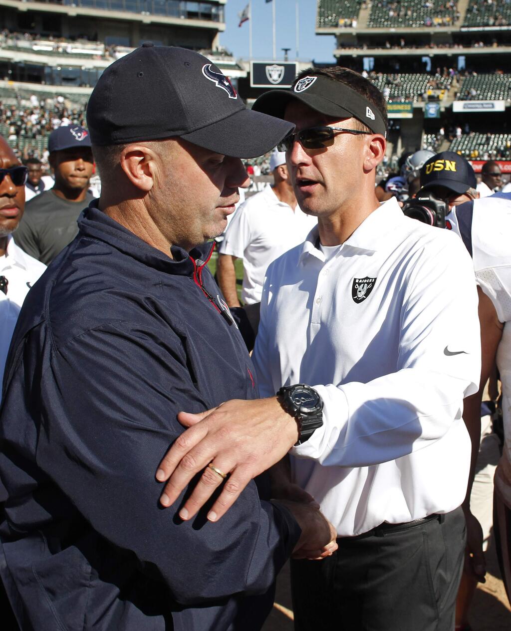 Houston Texans head coach Bill O'Brien, left, and Oakland Raiders head coach Dennis Allen, right, greet each other at the end of an NFL football game Sunday, Sept. 14, 2014, in Oakland, Calif. Houston won the game 30-14. (AP Photo/Beck Diefenbach)
