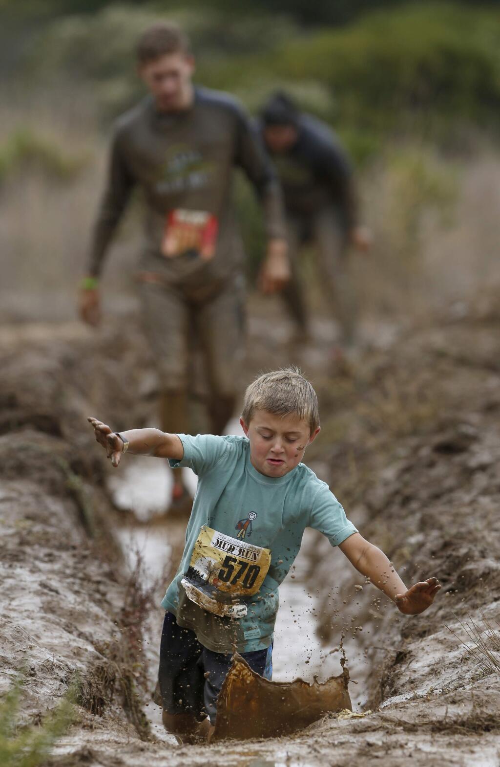 Vincent Pecoraro, 8, falls into a mud hole during the Russian River Mud Run at Rio Lindo Adventist Academy on Sunday, October 27, 2013 in Healdsburg, California. (BETH SCHLANKER/ The Press Democrat)