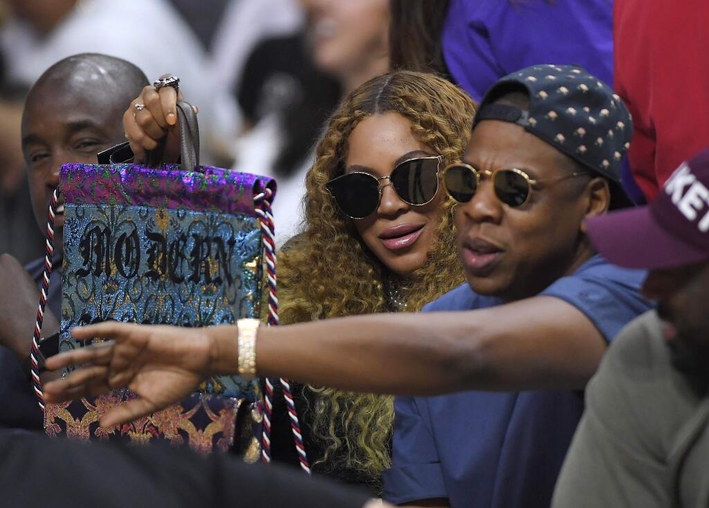 FILE - In this April 30, 2017, file photo, Beyonce and Jay Z watch during the first half in Game 7 of an NBA basketball first-round playoff series between the Los Angeles Clippers and the Utah Jazz in Los Angeles. Forbes reported on May 17, 2017, that it estimates the couple's combined wealth to be $1.16 billion. (AP Photo/Mark J. Terrill)