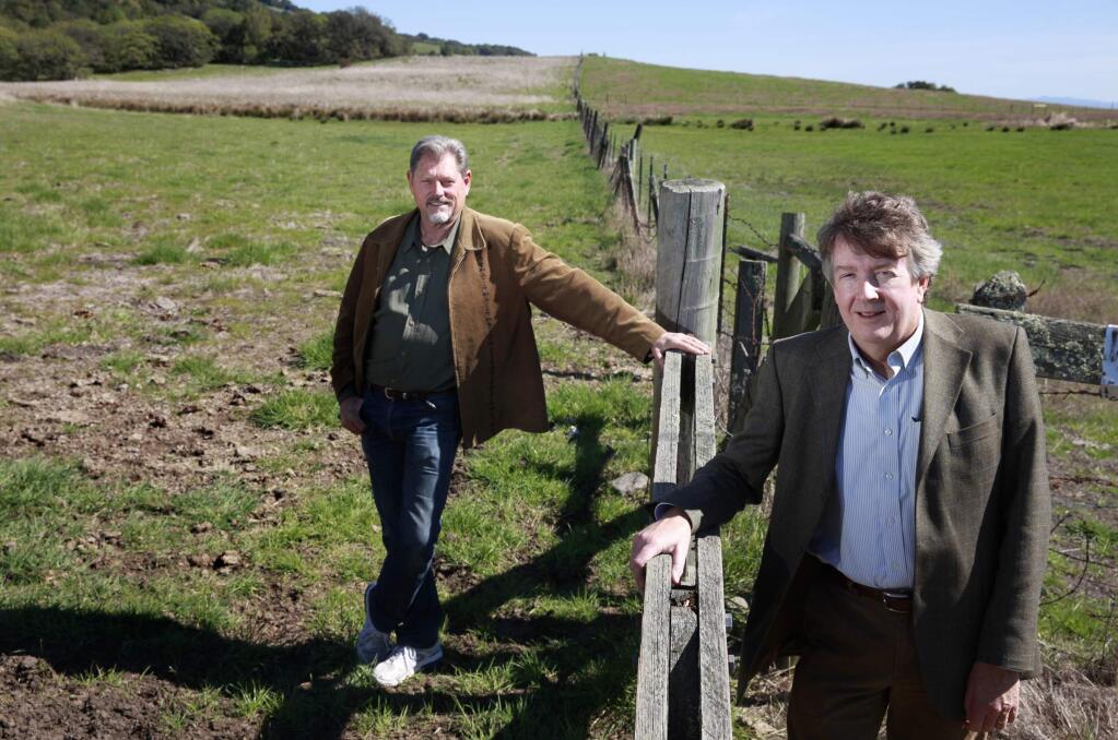 Former Petaluma City Councilman Matt Maguire, left, and present city council member Mike Healy stand at a gate to Lafferty Ranch, at left, which requires access from Sonoma Mountain Road across a corner in dispute. Photo taken on Monday, March 17, 2014 in Petaluma, California. To the right is the Tavernetti Family Land Trust. (BETH SCHLANKER/ The Press Democrat)
