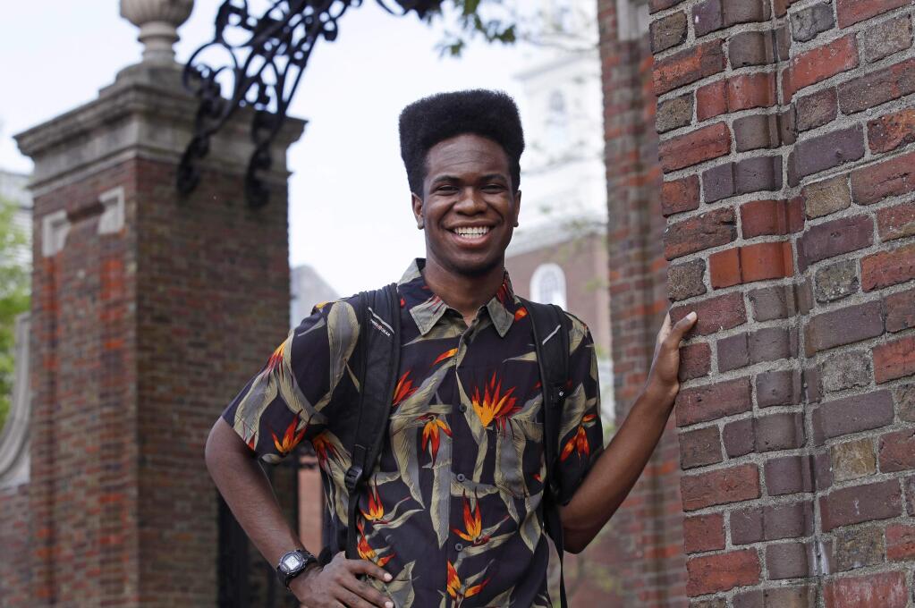 Obasi Shaw poses outside the gates of Harvard Yard in Cambridge, Mass., Thursday, May 18, 2017. Shaw, an English major who graduates from Harvard next week, is the university's first student to submit his final thesis in the form of a rap album. The record, called “Liminal Minds,” has earned the equivalent of an A- grade, good enough to ensure that Shaw will graduate with honors at the university's commencement next week. (AP Photo/Charles Krupa)