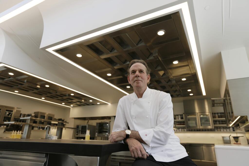 FILE - This March 9, 2017, file photo, shows celebrated chef Thomas Keller in the kitchen of his French Laundry restaurant in Yountville, Calif. A former employee of celebrated chef Thomas Keller is suing him and his three-star Michelin restaurants, Per Se in New York and the French Laundry in California, for discrimination, saying she was denied a job transfer and ultimately let go because she was pregnant. Vanessa Scott-Allen is seeking $5 million in damages for allegations that include sex discrimination and violation of pregnancy disability leave and says she hopes her trial, which starts Monday, June 3, 2019, will draw attention to a 'culture of misogyny in fine dining,' said her attorney, Carla Minnard. (AP Photo/Eric Risberg, File)