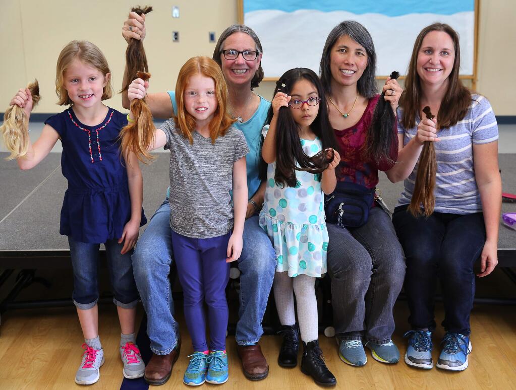 Ellie Bugarske, left, Hazel Bugarske, Marci Cook, Camila Vazquez, Joanna Huie and Charity Higareda hold up the hair that they had cut off to donate to Wigs for Kids, at Mattie Washburn Elementary School in Windsor, on Thursday, February 25, 2016. (Christopher Chung/ The Press Democrat)