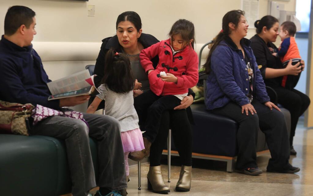 At the Rohnert Park Health Care Center, from left, Adrian Rodriguez with his family Camilla and Priscilla and wife Stella, wait for their children to be seen by a doctor at the center, Thursday Jan. 28, 2016. As a result of the Affordable Health Care Act, thousands of people are now eligible for health care, creating a doctor shortage. The center is operated by the Petaluma Health Center. (Kent Porter / Press Democrat) 2016
