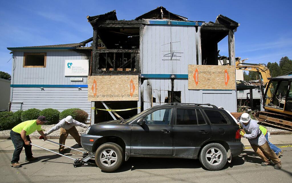 Before continuing with the demolition of Guerneville's Russian River Health Center, gutted by a possible arson fire in December, crews move a car Monday after the owner could not be found. (Kent Porter / The Press Democrat)