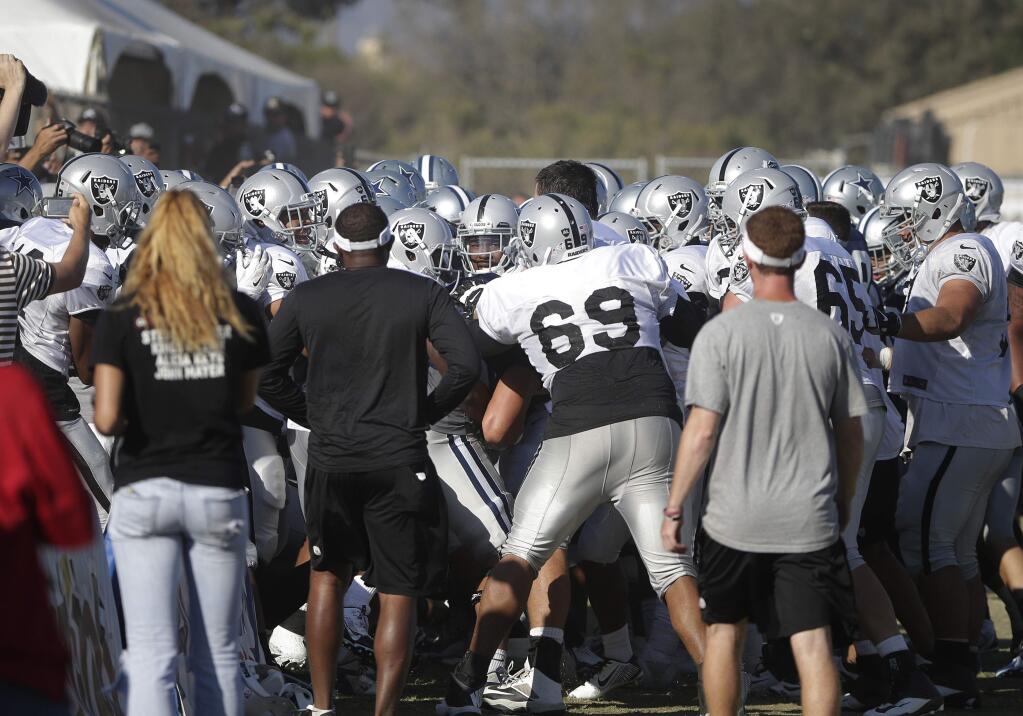 The Oakland Raiders and the Dallas Cowboys players engage in a scuffle during a joint football practice on Tuesday, Aug. 12, 2014, in Oxnard, Calif. (AP Photo/Jae C. Hong)