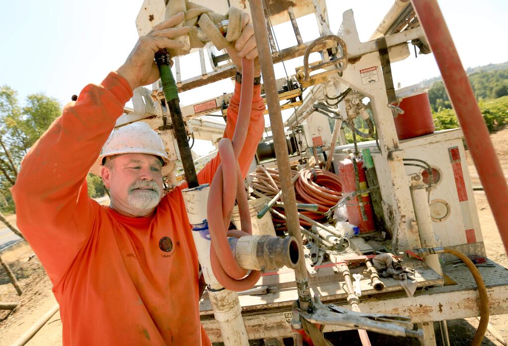 Daryl Whitley of Roadrunner Drilling and Pump Company lifts a water pipe from a newly drilled monitoring well in Redwood Valley, Wednesday Sept. 3, 2014. The depth of the cut was nearly 350 feet deep. (Kent Porter / Press Democrat)