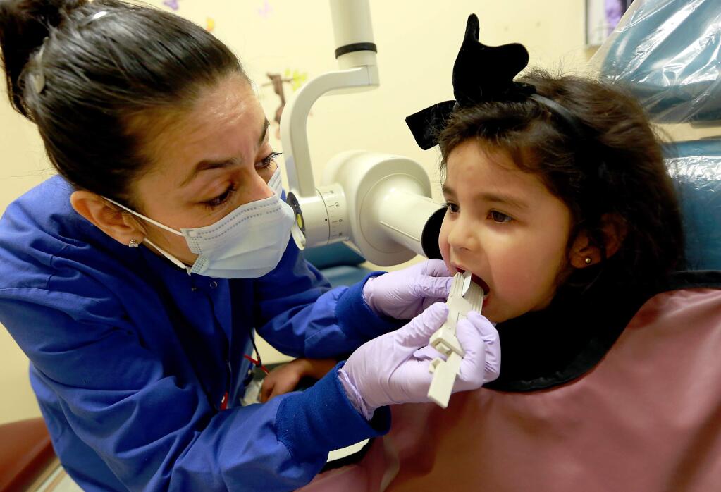 Dental hygenist Erika Rosebaugh takes X-rays of Nicole Rivera's, 4, teeth at the Santa Rosa Community Health Dental Clinic on Feb. 5, 2016. (JOHN BURGESS / The Press Democrat)