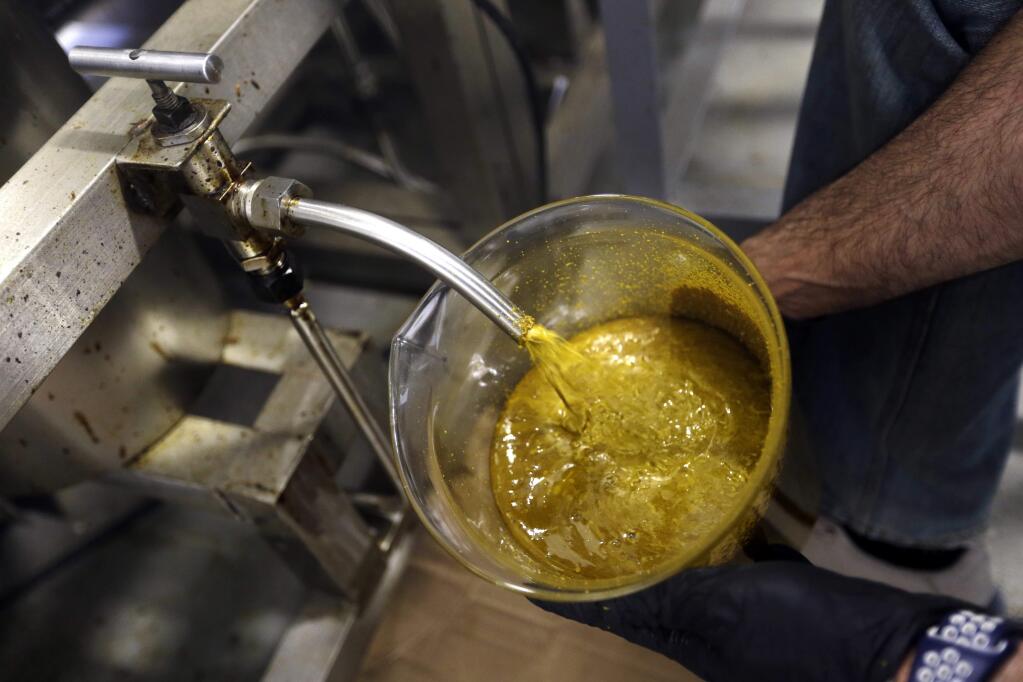 FILE - In this April 24, 2018, file photo, the first rendering from hemp plants extracted from a super critical CO2 extraction device on it's way to becoming fully refined CBD oil spurts into a large beaker at New Earth Biosciences in Salem, Ore. The hemp industry still has work ahead to win legal status for hemp-derived cannabidiol, or CBD oil. The head of the Food and Drug Administration says adding CBD to food or dietary supplements is still illegal. President Donald Trump signed a farm bill this week designating hemp as an agricultural crop, but FDA Commissioner Scott Gottlieb issued a statement saying CBD is a drug ingredient and therefore illegal to add to food or supplements without approval from his agency. (AP Photo/Don Ryan, File)