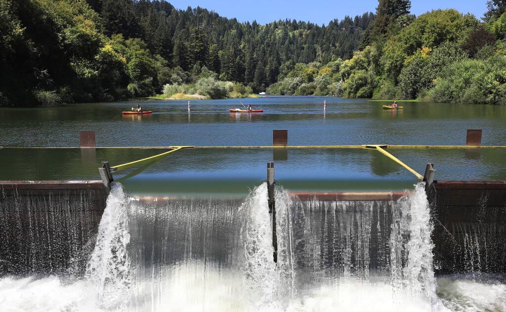Kayakers prepare to portage around the Vacation Beach dam and fish ladder, Thursday, Aug. 15, 2019, in Guerneville. (Kent Porter / The Press Democrat, 2019)