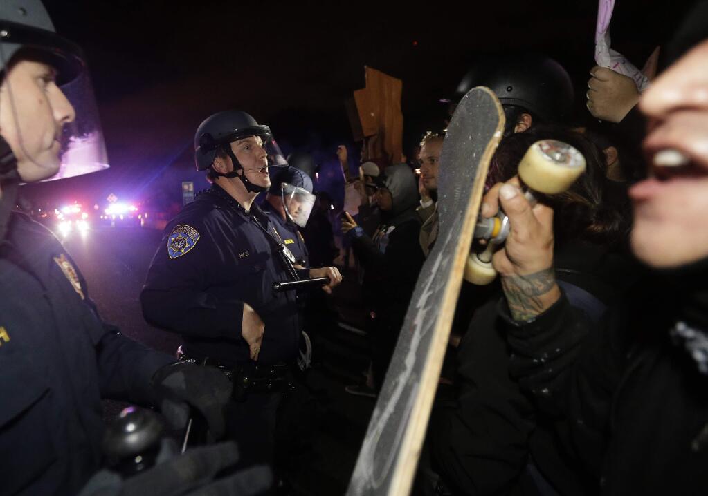 California Highway Patrol officers try to keep back protesters who blocked Highway 80 in response to police killings in Missouri and New York in Berkeley, Calif., Monday, Dec. 8, 2014. (AP Photo/Jeff Chiu)