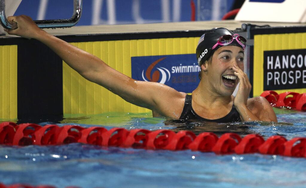 Maya Dirado of the U.S. smiles as she looks back to the score board after she won her women's 200m individual medley final at the Pan Pacific swimming championships in Gold Coast, Australia, Sunday, Aug. 24, 2014. (AP Photo/Rick Rycroft)