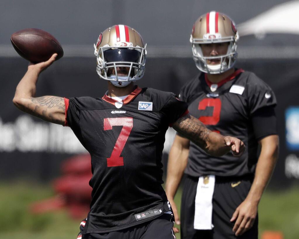 In this Sunday, July 31, 2016 file photo, San Francisco 49ers quarterback Colin Kaepernick (7) throws as quarterback Blaine Gabbert watches during training camp in Santa Clara. Colin Kaepernick will get one more chance to impress coach Chip Kelly before the San Francisco 49ers announce their starting quarterback even as the debate surrounding Kaepernick's refusal to stand for the national anthem remains heated. (AP Photo/Marcio Jose Sanchez, File)