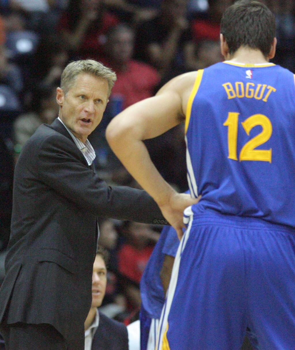Golden State Warriors coach Steve Kerr, left, instructs Andrew Bogut during the second half of an NBA preseason basketball game in Hidalgo, Texas, Sunday, Oct. 19, 2014. (AP Photo/Delcia Lopez)