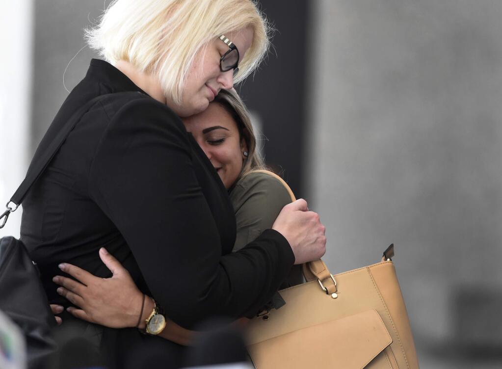 Sirley Silveira Paixao, right, an immigrant from Brazil seeking asylum, hugs her Chicago based attorney Britt Miller, after a hearing where a federal judge ordered the release of her 10-year-old son Diego from immigration detention, Thursday, July 5, 2018, in Chicago. Silveira Paixao arrived in this country with her son on May 22 and was separated from him shortly after. (AP Photo/Annie Rice)