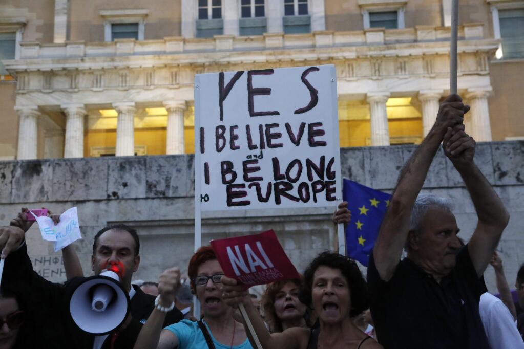 Demonstrators shout slogans during a rally organized by supporters of the YES vote for the upcoming referendum in front of the Greek Parliament in Athens, Tuesday, June 30, 2015 Greece's European creditors were assessing a last-minute proposal Athens made for a new two-year rescue deal, submitted just hours before the country's international bailout program expires and it loses access to billions of euros in funds. (AP Photo/Petros Karadjias)